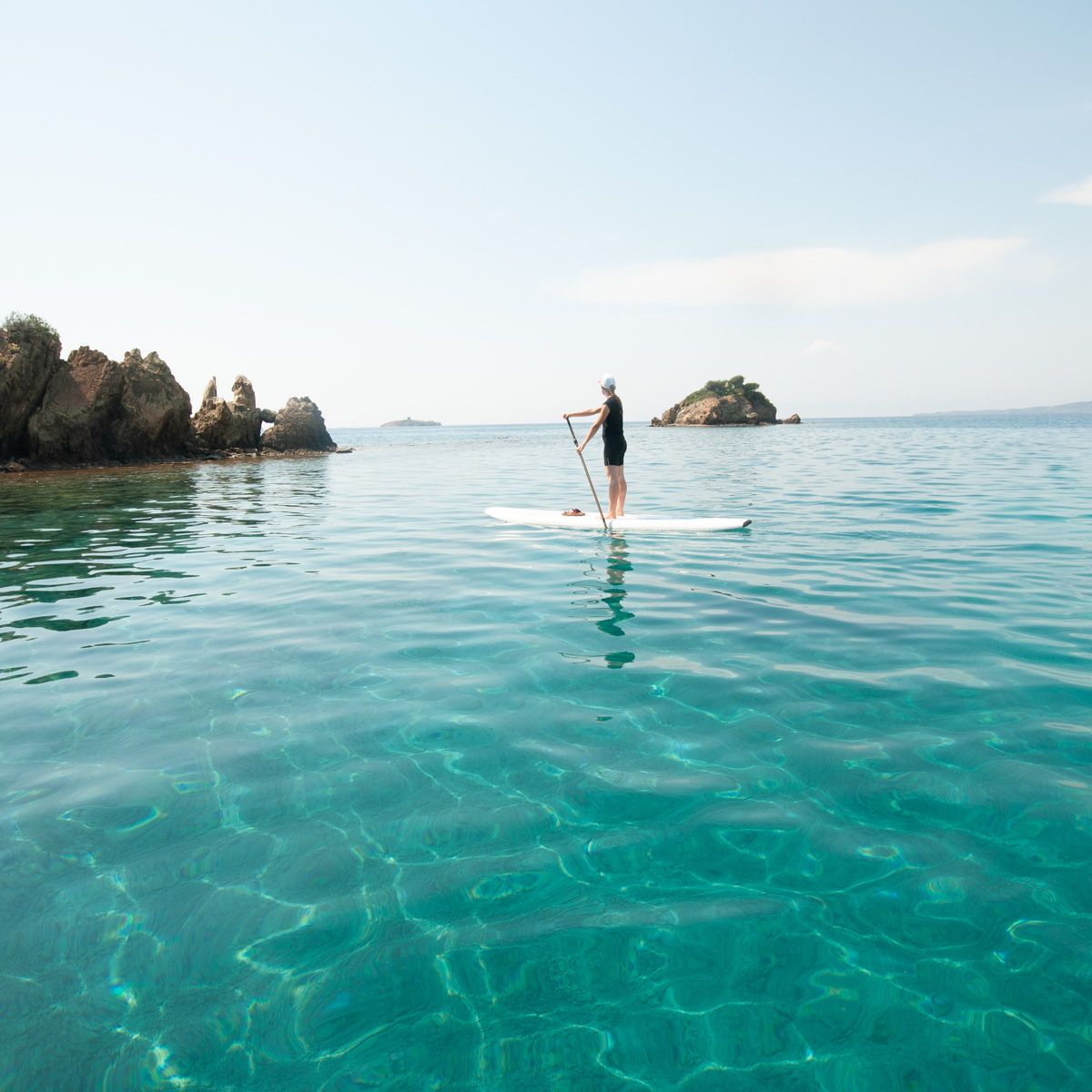 paddle boarder in turquoise colored waters of Balikasiran
