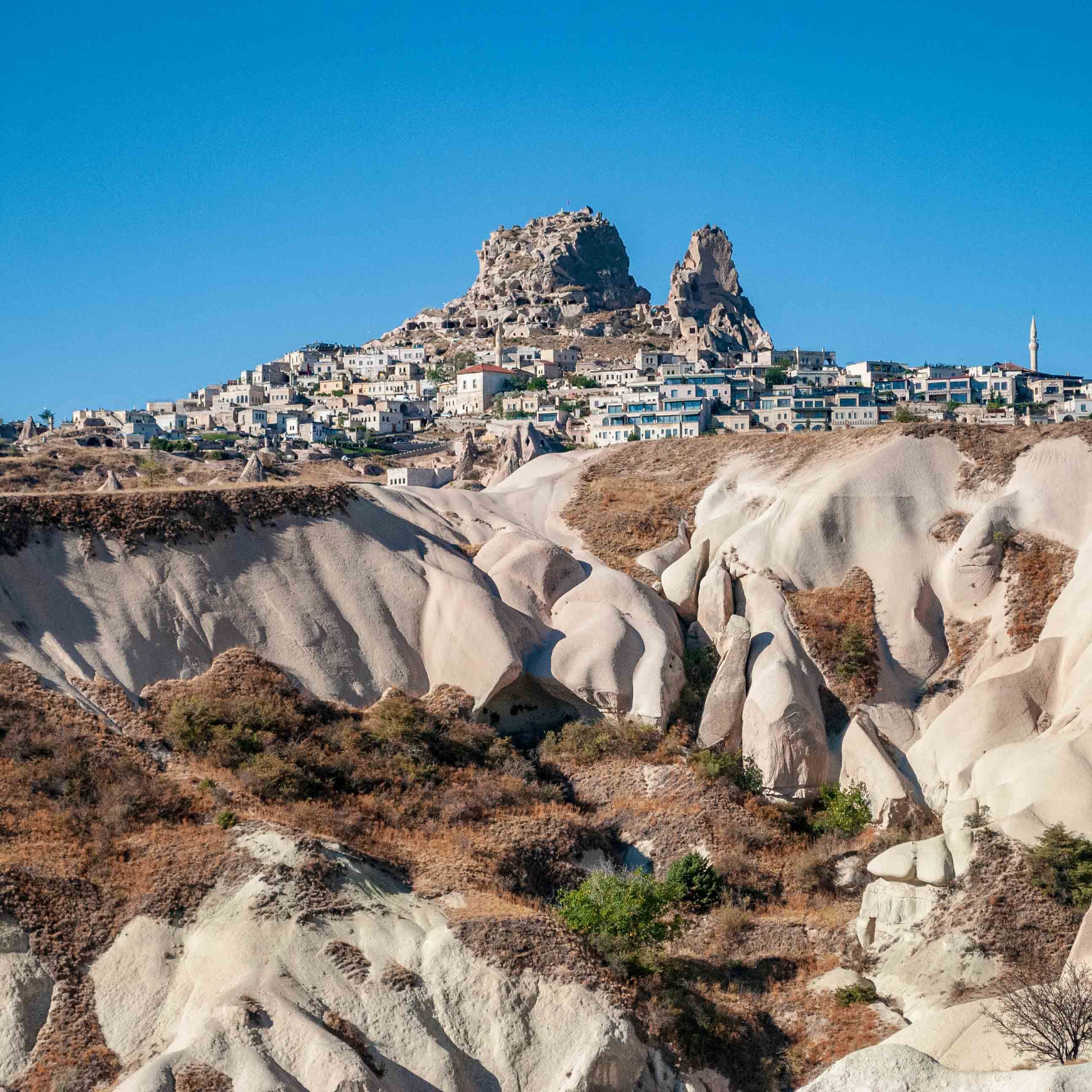 Uchisar Castle behind the rock formations of Cappadocia 