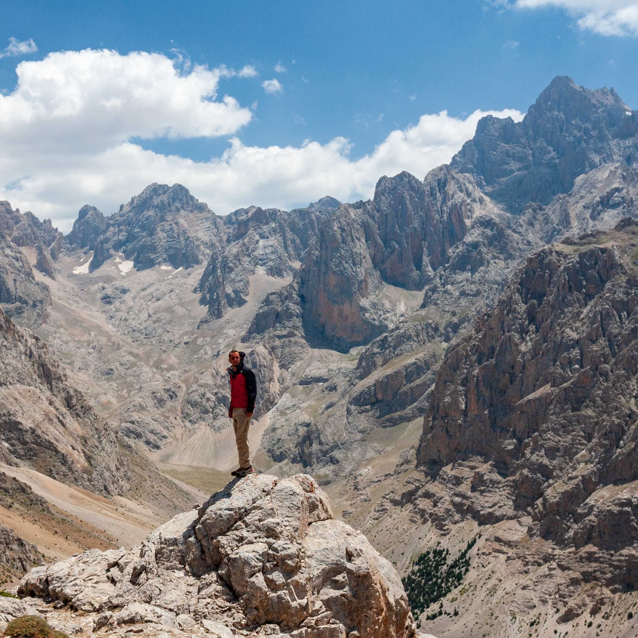 Hiker standing on a rock edge amidst the peaks of Taurus Mountains 